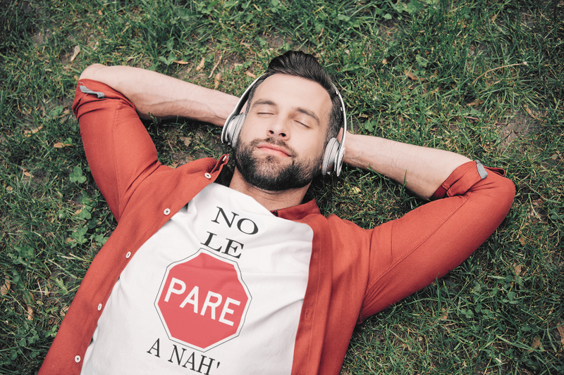 t shirt mockup of a relaxed man lying on the grass with headphones
